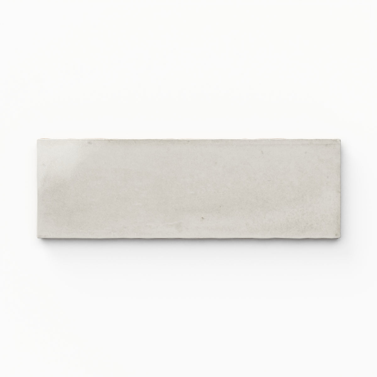 A 2x6 porcelain tile in off white , featuring a glossy finish, soft tonal variation, and a clean, flat-edge profile.