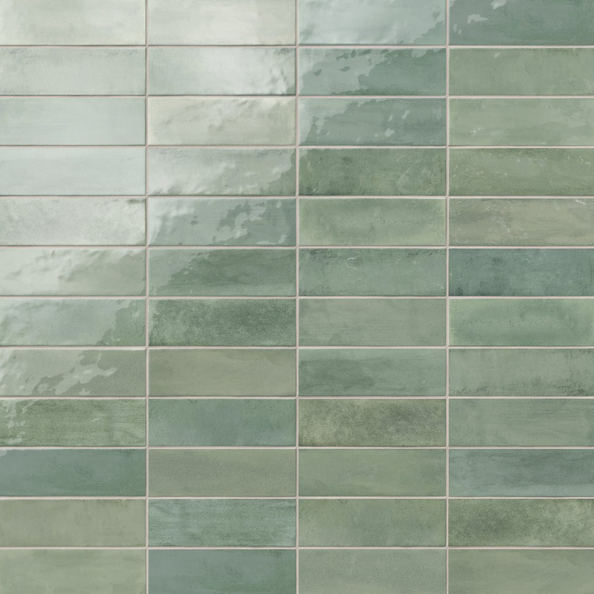Glossy subway tiles in shifting green tones with an artisan-like surface