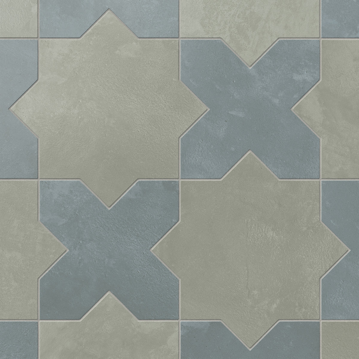 This matte porcelain tile pairs star and cross forms in alternating earth-drawn hues of muted sage green and blue, softened by subtle cement-plaster texture and a powdery glaze inspired by handmade terracotta.