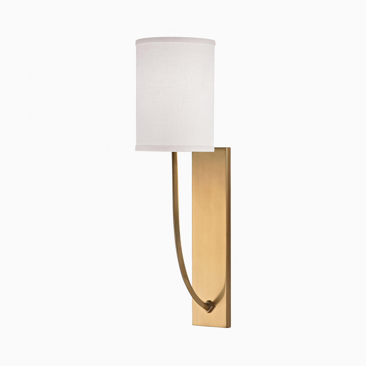 Wall sconce with a cylindrical white linen shade and curved arm on an aged brass backplate, offering understated modern elegance.