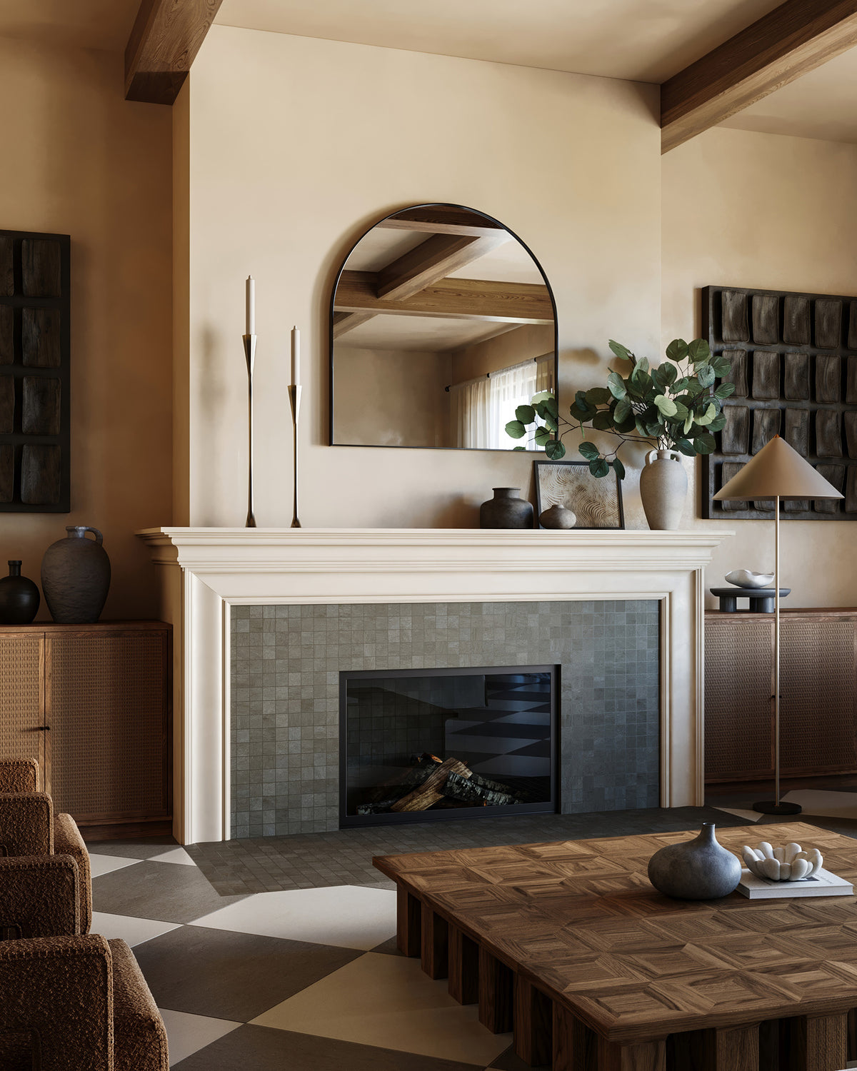 Brody Smoke matte 2x2 mosaic tile surrounds a modern fireplace, topped with a wide arched mirror in a warm, textured living space