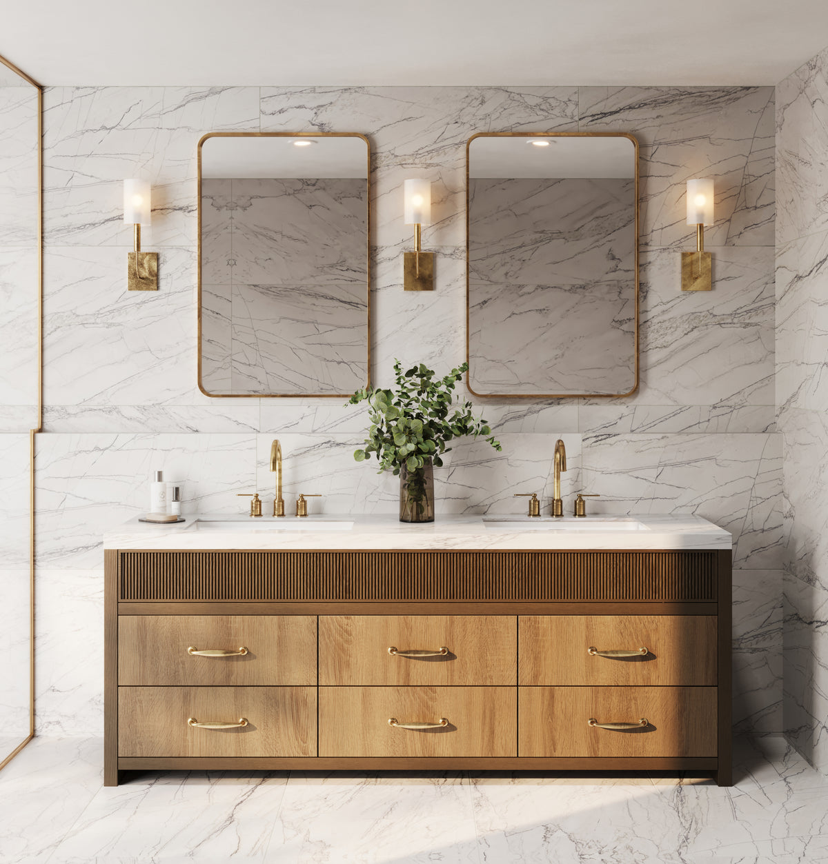 A luxurious bathroom with marble look walls and floors, a double vanity in warm wood tones with fluted detailing, gold fixtures, and matching sconces for an opulent ambiance.