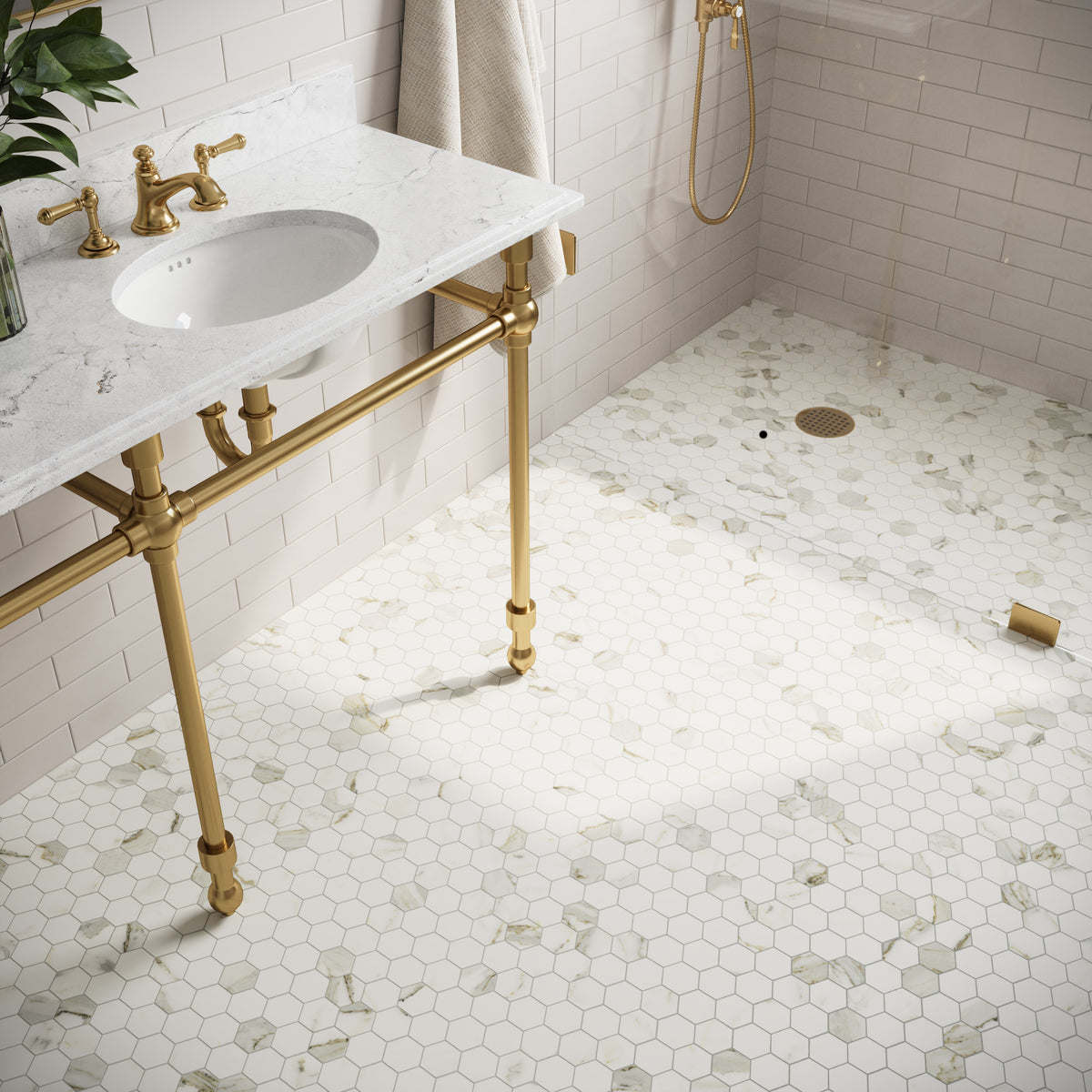Elegant bathroom with Calacatta Top hexagon mosaic marble look flooring, white subway wall tiles, marble countertop, and gold fixtures for a luxurious touch.