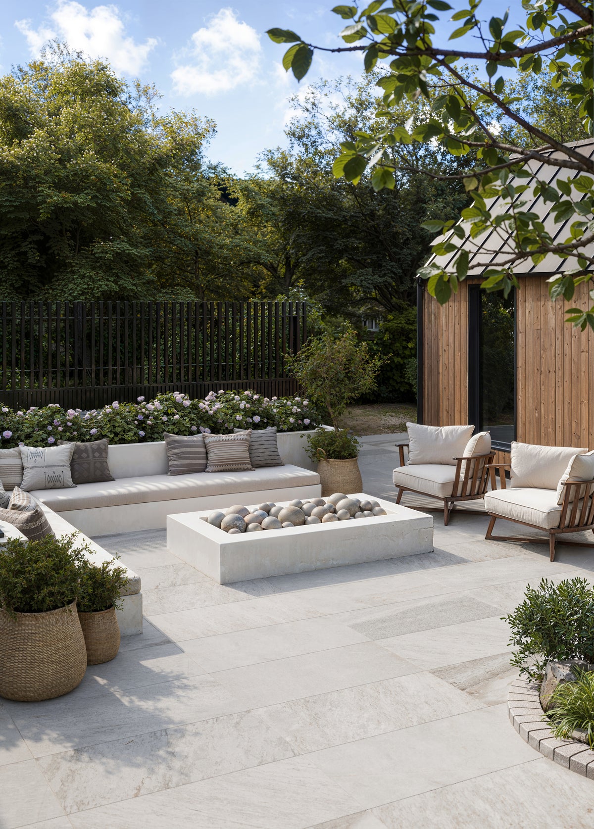 Spacious patio design using Carter Stone 24x48 Matte Pavers in 2cm thickness, complemented by natural surroundings and a cozy lounge area.