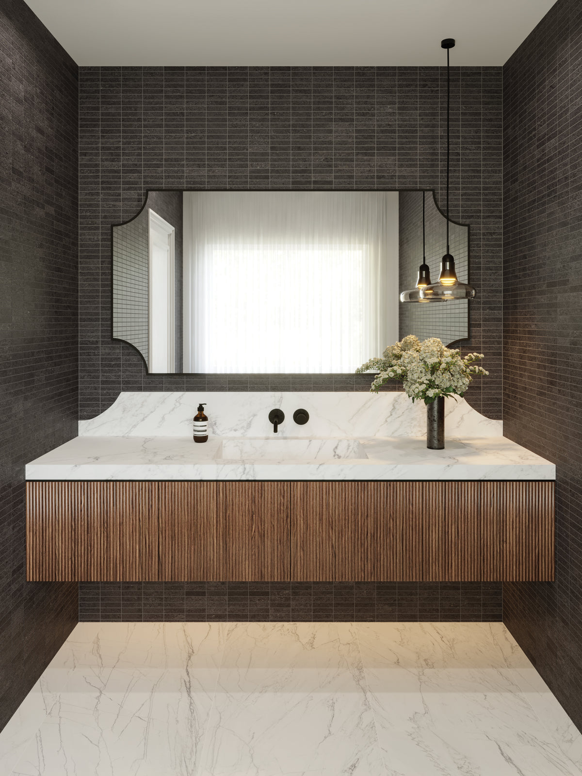 A striking bathroom with midnight black mosaic tiles, a floating fluted wood vanity, and marble look countertops, complemented by bold black fixtures and elegant pendant lighting.
