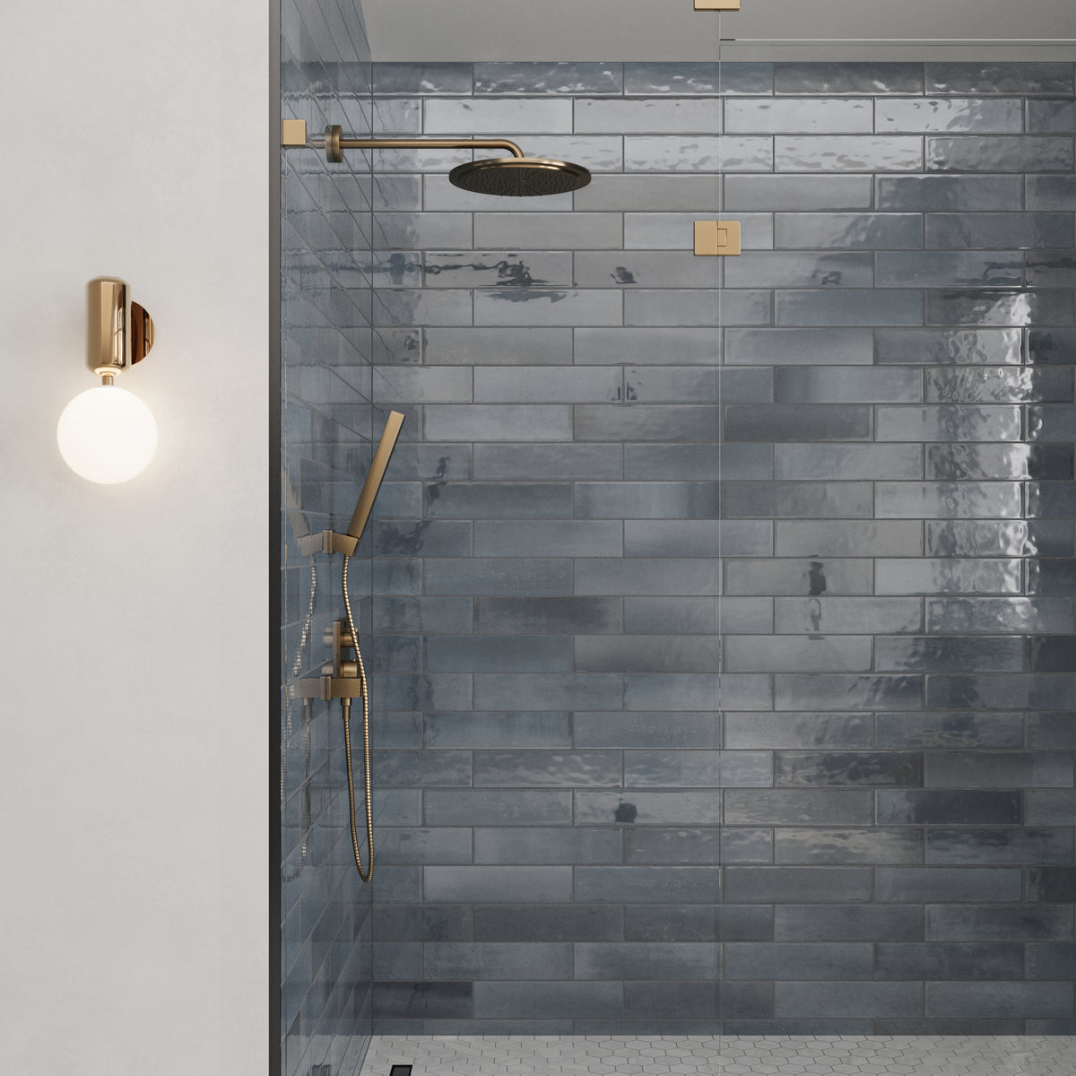 Glossy blue subway tiles with gold fixtures bring elegance and shine to this modern shower space.