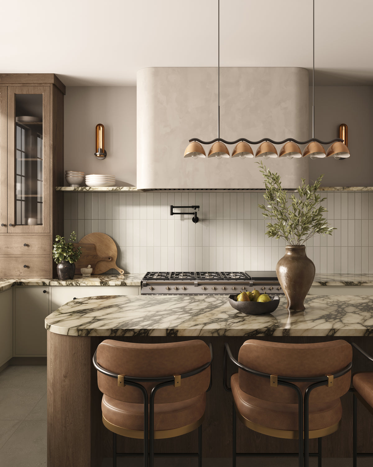 Modern kitchen with marble waterfall island, vertical white subway tile backsplash, brown counter stool, and sculptural linear pendant with seven beige dome shades.