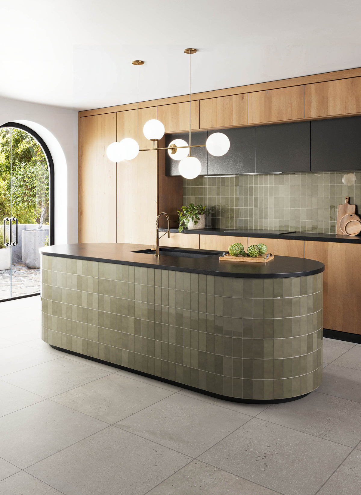 Kitchen featuring Sloane 24x24 matte porcelain tiles in Sandstone on the floor, complemented with olive green subway tiles on the island and backsplash, natural wood cabinetry, and black accents for a warm and sophisticated look.