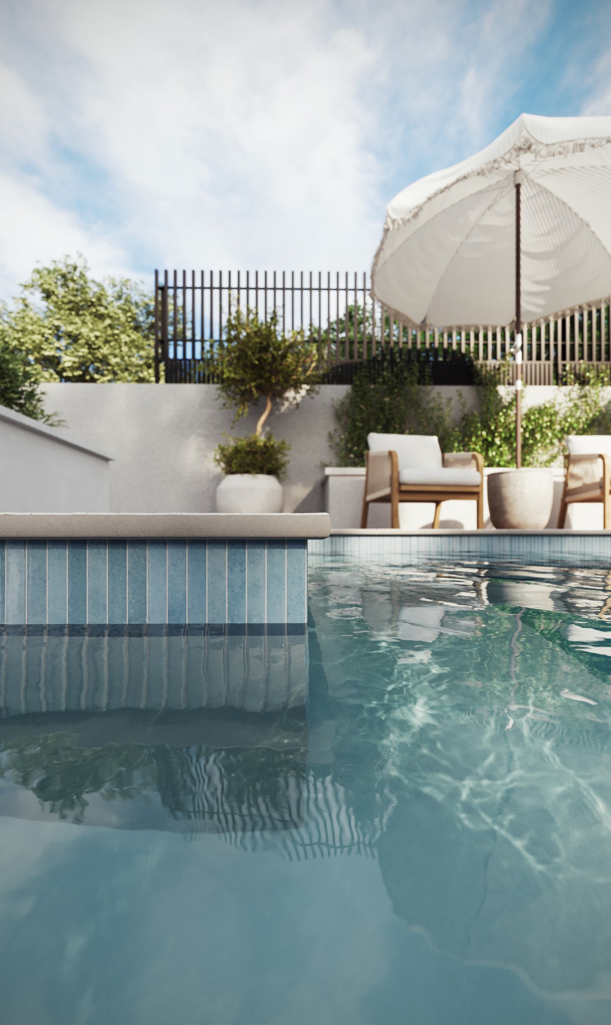Bowden Canvas 24x24 2CM Grip tiles in a soft cream finish surround a sparkling pool, with modern lounge chairs and lush greenery completing the serene backdrop.