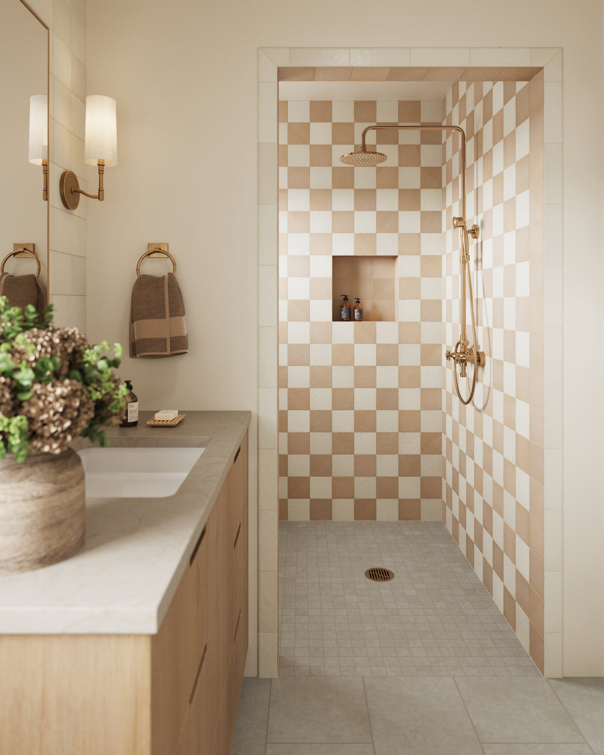 Bright and inviting bathroom featuring Wyatt Ash 12x24 matte porcelain tiles on the floor, paired with a warm checkered shower design and brass fixtures for a modern yet cozy aesthetic.