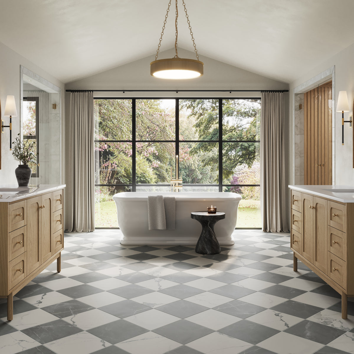 Pair of wall sconces with white linen cone shades and brass-black stems, symmetrically flanking a freestanding bathtub.