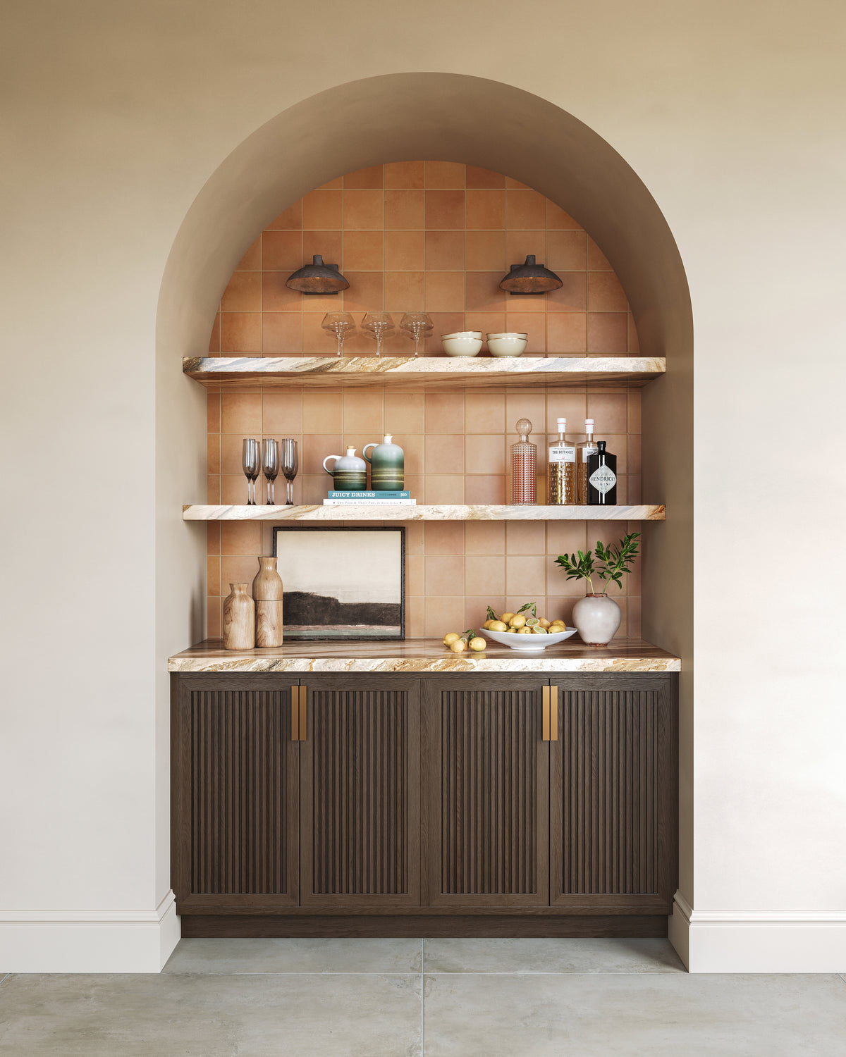 Arched bar niche with terracotta tile, marble shelves, dark wood cabinet, and black dome sconces styled with glassware and bottles