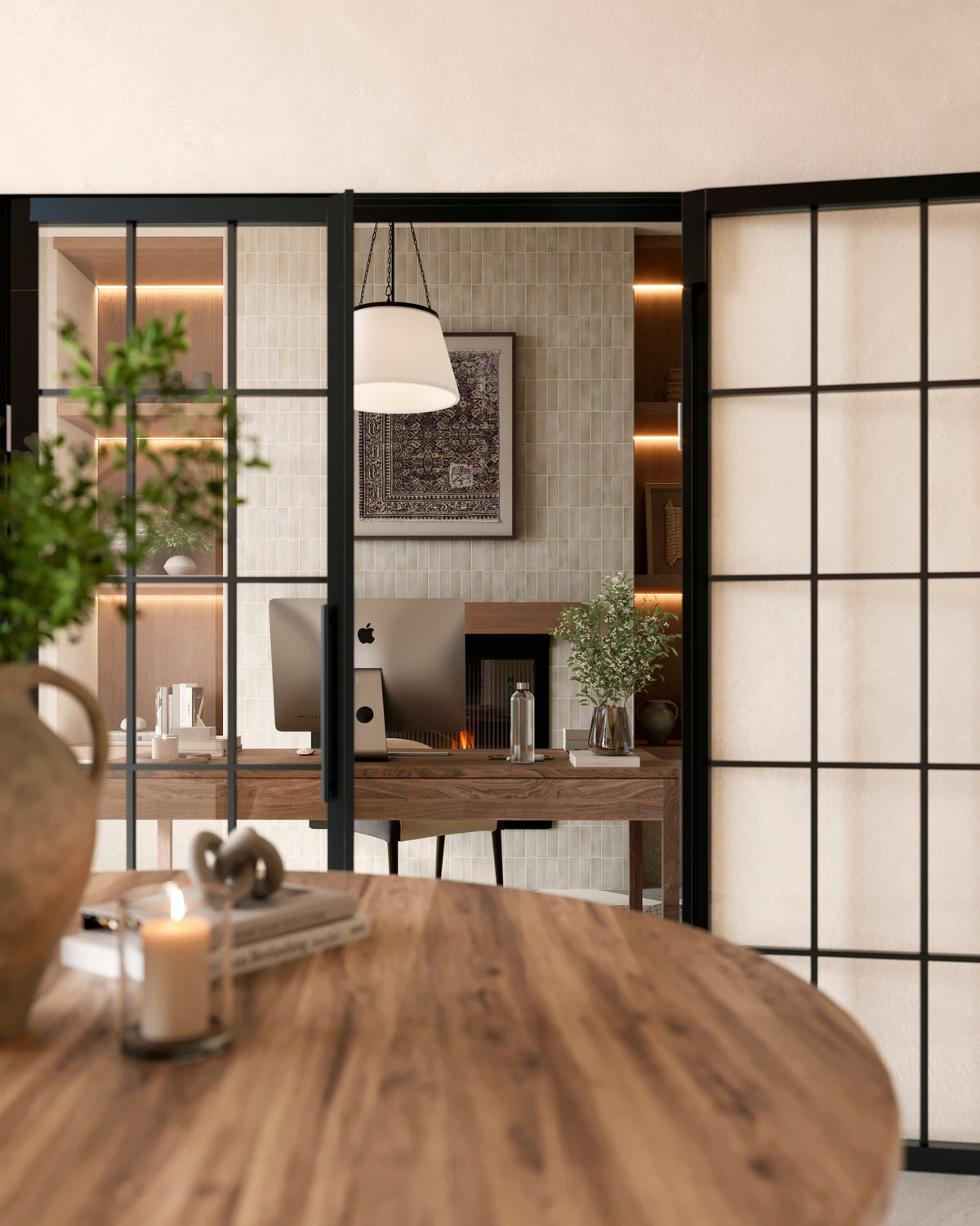 Modern office with a wood desk, iMac, and soft green vertical subway tiles, framed by black grid glass doors and ambient pendant lighting.