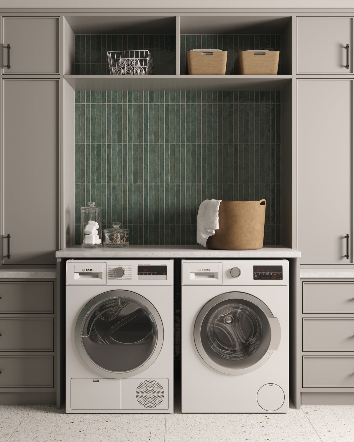 Modern laundry room with stacked storage cabinetry, vertical green tile backsplash, and front-loading washer and dryer integrated into a clean, organized design.