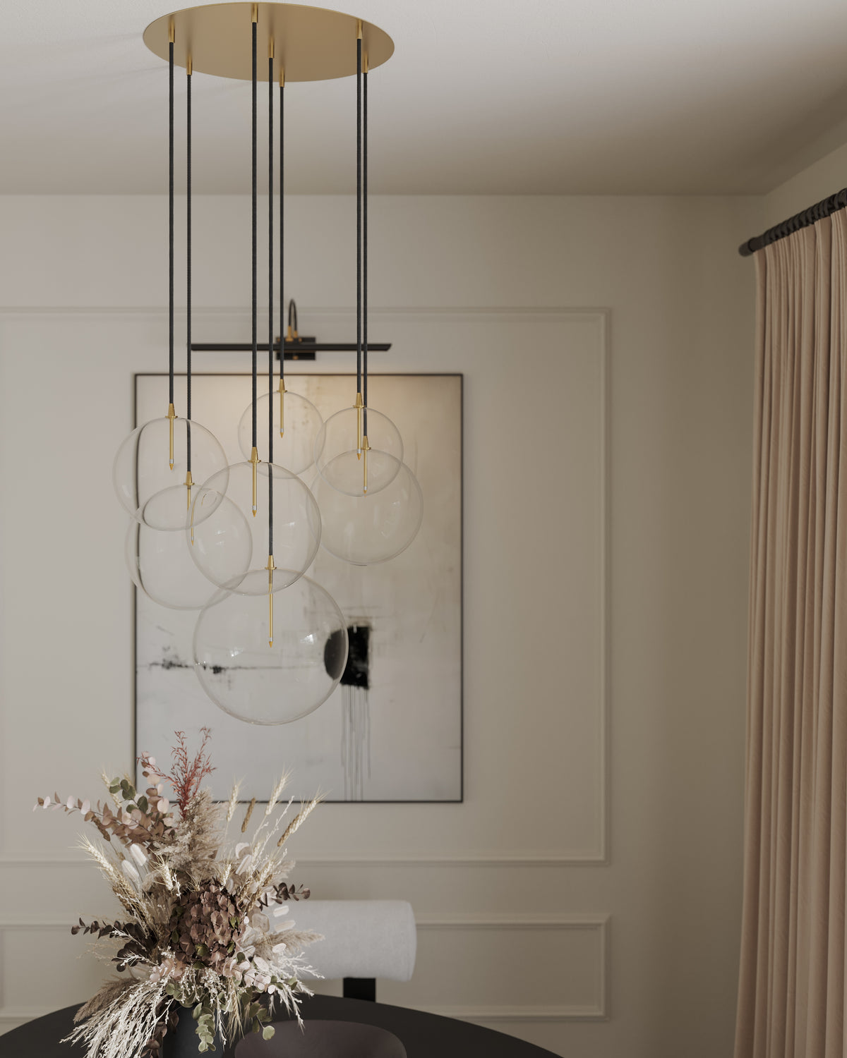 Modern glass globe chandelier with brass accents hangs above a dining table, set against soft paneled walls and neutral drapery