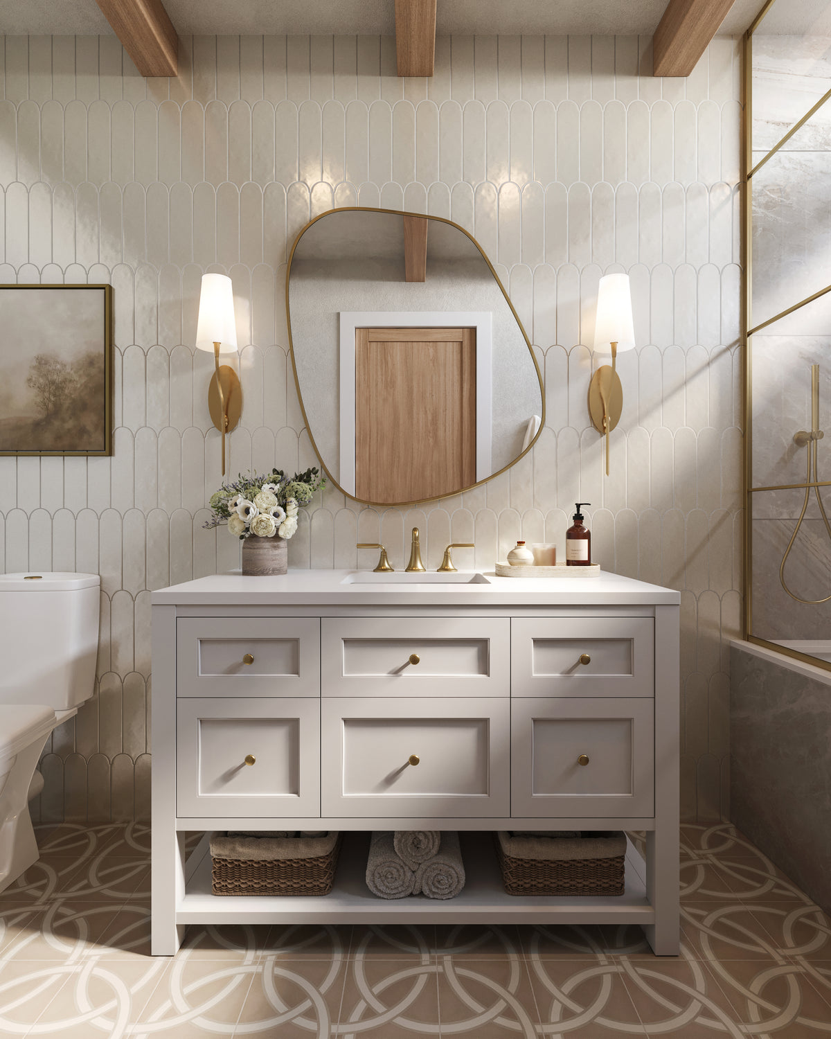 Bridgette single bathroom vanity in Bright White with a white quartz countertop, featuring six drawers with brass hardware and an open lower shelf with baskets and towels, styled with a sculptural mirror, brass sconces, patterned tile flooring, and a glass shower enclosure.