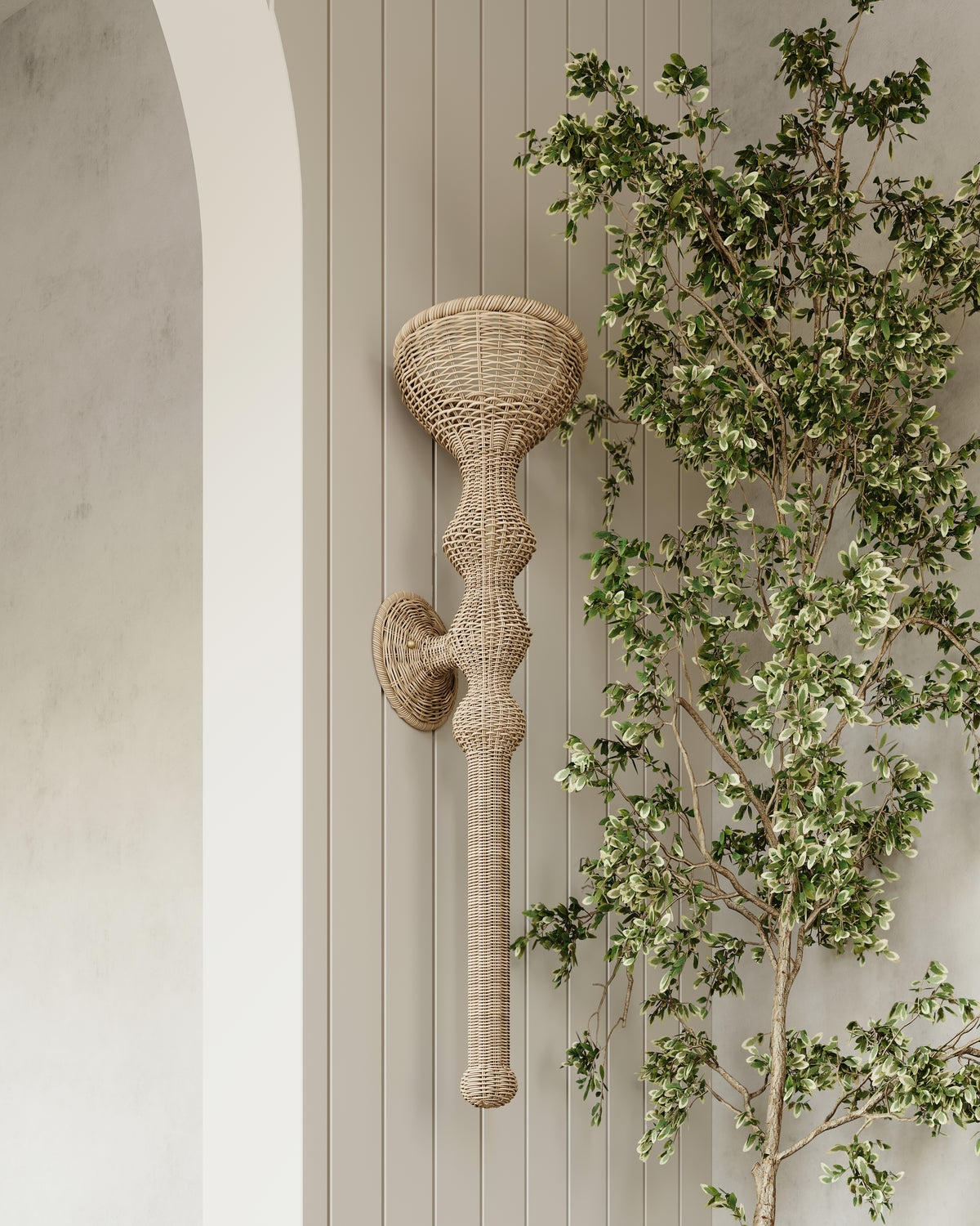 Natural woven rattan wall sconce mounted on vertical panel wall beside leafy plant, bringing texture and soft ambient lighting.