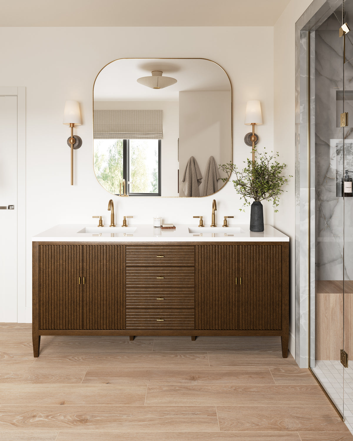 Modern bathroom vanity with fluted wood cabinet, brass faucets, large rounded mirror, and flared woven semi-flush ceiling light overhead