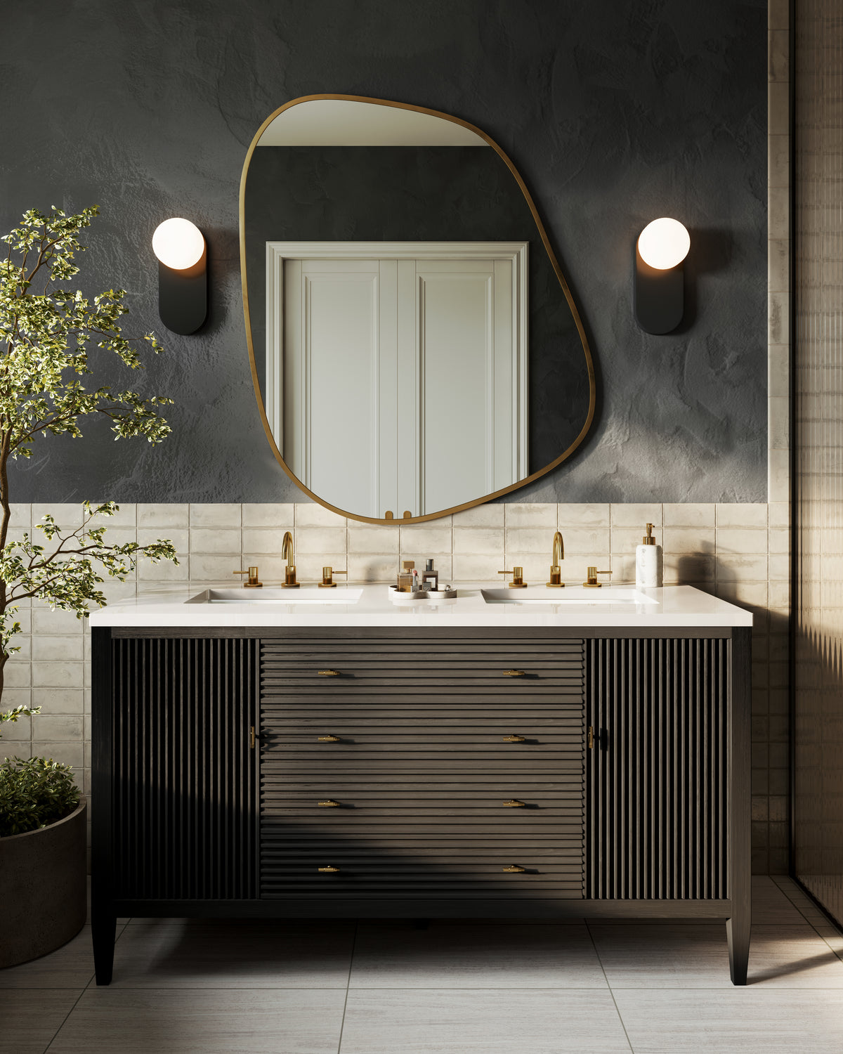 Carbon oak double vanity with fluted drawers, white countertop, brass faucets, and sculptural mirror against dark textured wall.
