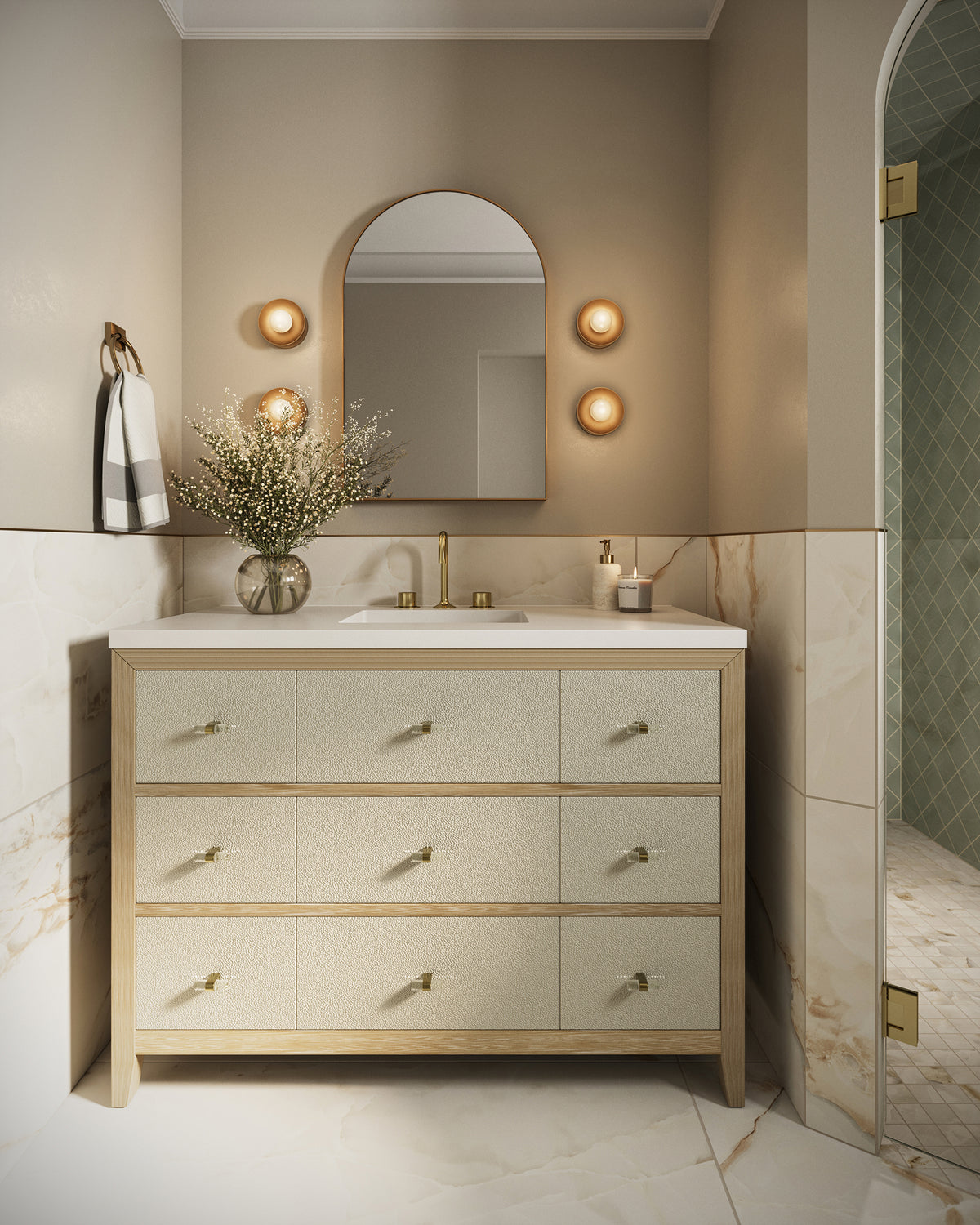 Elegant bathroom with single sink vanity, arched mirror, warm sconces, and marble look wall tiles.