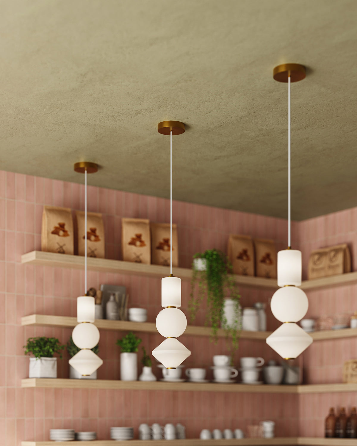 Universal voltage LED modern pendant lights with gold canopy and sculptural stacked white glass shades above café shelving with pink subway tile wall.