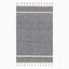 Boho-inspired hand loomed wool area rug with a navy and white geometric diamond pattern and tassel fringe, blending style and texture.