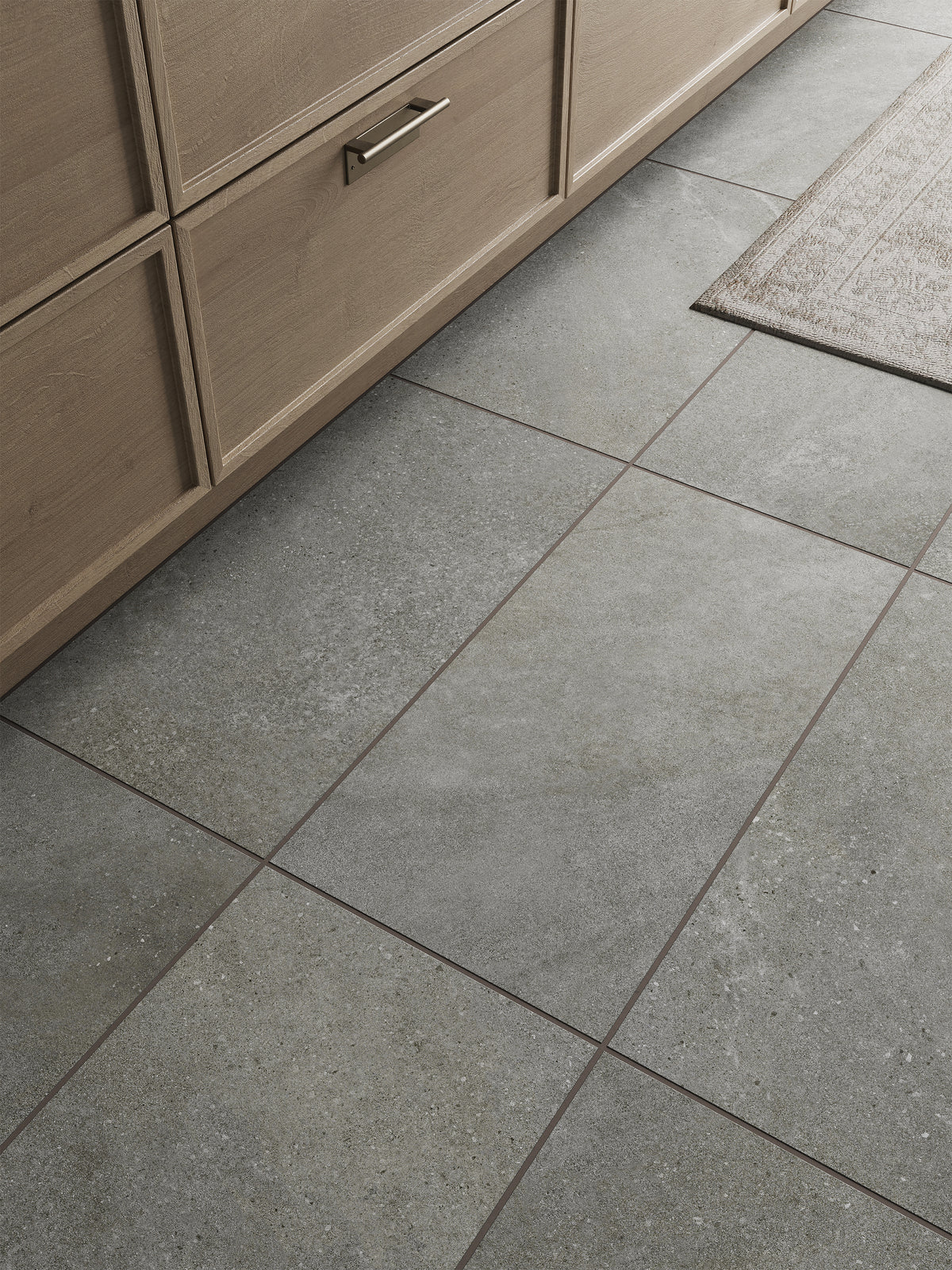 Stylish gray matte tiles on a kitchen floor, complementing the warm beige cabinetry and soft rug accents.