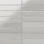 Glossy light gray rectangular ceramic tiles with subtle speckling, softened edges, and light grout lines in a stacked wall pattern.