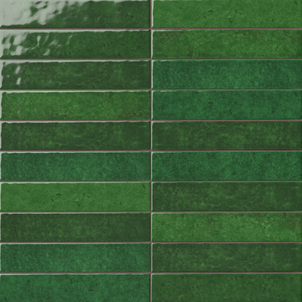 Green 2x13 ceramic wall tiles arranged in a linear layout, showcasing layered color movement, a lustrous surface, and artisanal character throughout the installation.