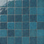 Blue 4x4 ceramic wall tiles installed in a square grid pattern, highlighting organic tonal depth, mottled surface variation, and handcrafted detailing.