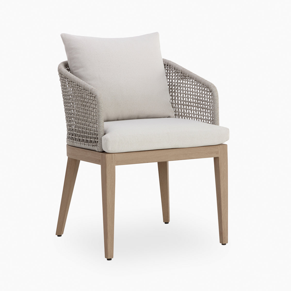 Outdoor dining chair with a light natural wood frame, off-white upholstered seat and back cushions, curved arms, and beige open-weave rope sides on a plain white background.