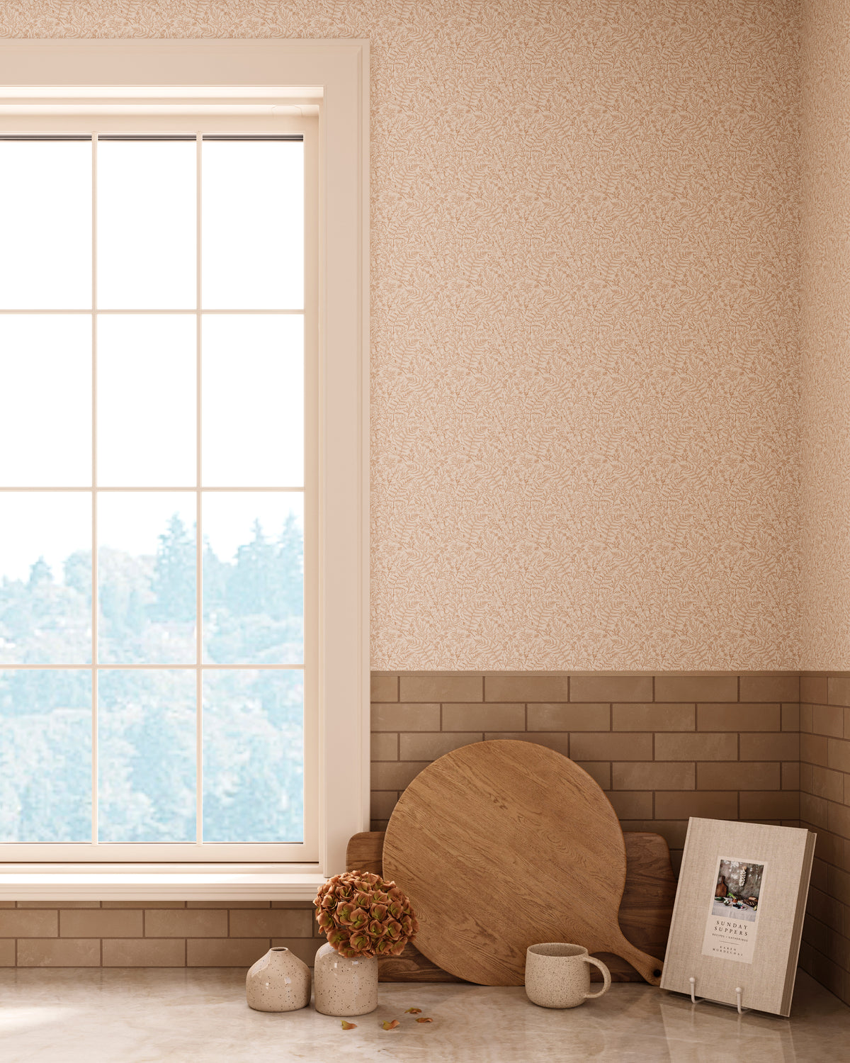 Bright kitchen corner featuring Strafford Wallpaper in Tan II with a delicate light brown botanical pattern on a soft white base, styled with a large window, beige subway tile backsplash, wooden cutting boards, ceramic decor, and a framed photo on the countertop.