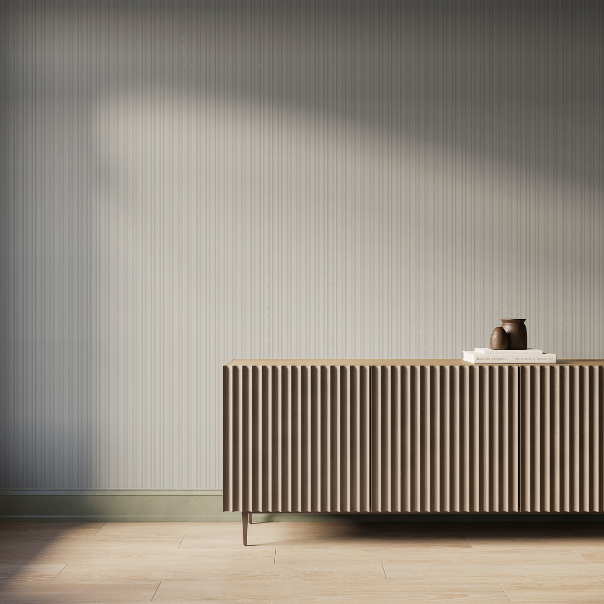 Modern interior featuring soft white and light gray vertical striped wallpaper, a fluted console cabinet in a warm wood tone, light wood flooring, and soft natural light casting gentle shadows across the textured wall.