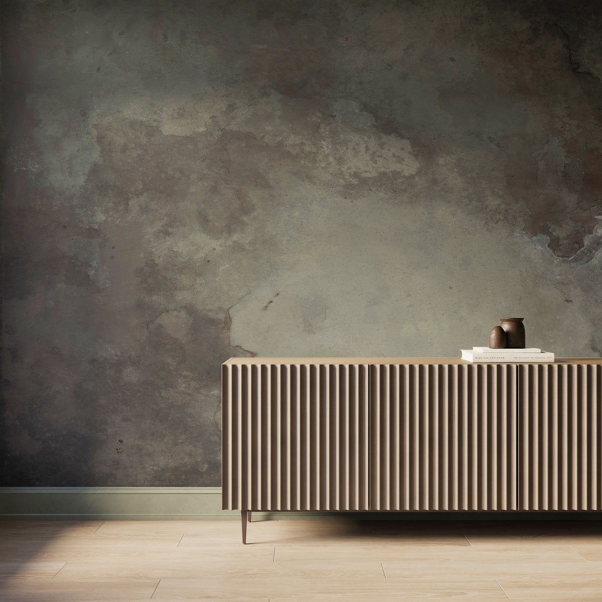 Interior scene featuring the Skyveil Mural in Mistfall IV with layered dark taupe and sandy beige abstract textures, styled behind a fluted wood console cabinet with light wood flooring and soft natural light across the wall.