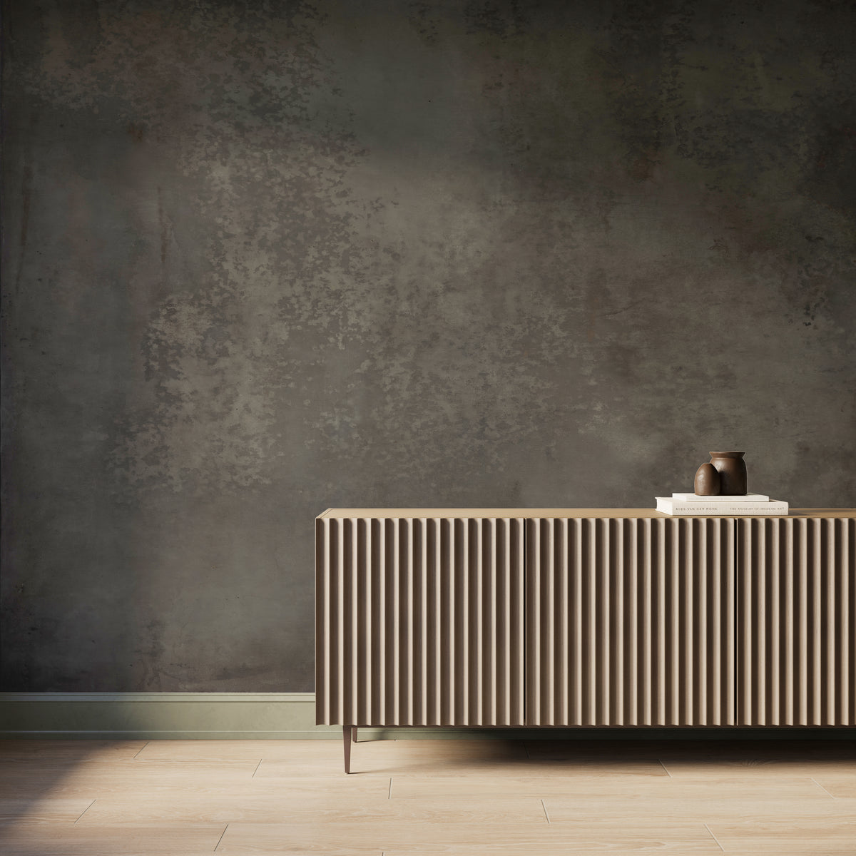 Interior scene featuring the Skyveil Mural in Mistfall III with layered gray washes and earthy undertones in an abstract plaster-like design, styled behind a fluted wood console cabinet with light wood flooring and soft natural light across the wall.