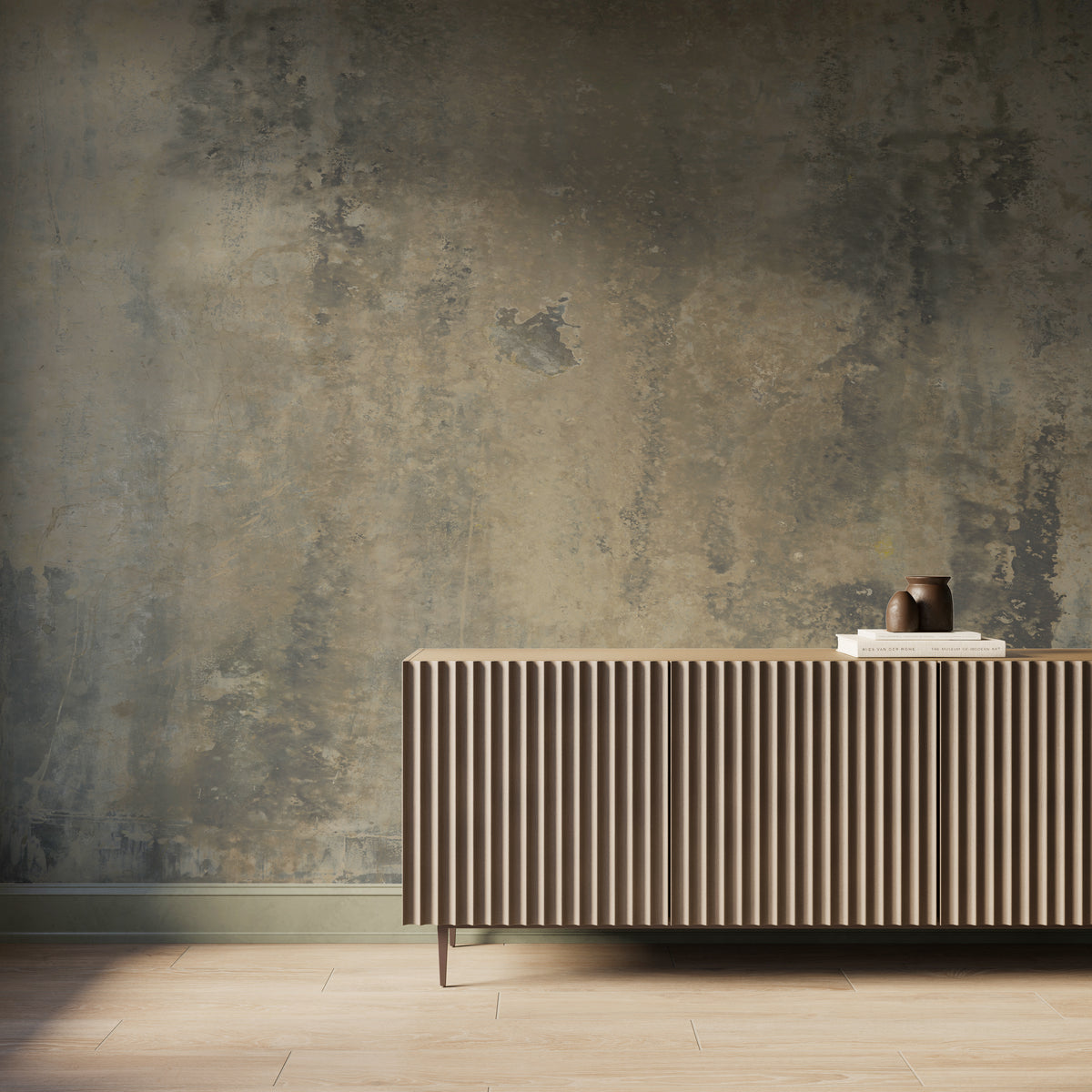Interior scene featuring the Skyveil Mural in Mistfall I with layered smoky gray and sandy beige abstract textures, styled behind a fluted wood console cabinet with light wood flooring and soft natural light washing across the wall.
