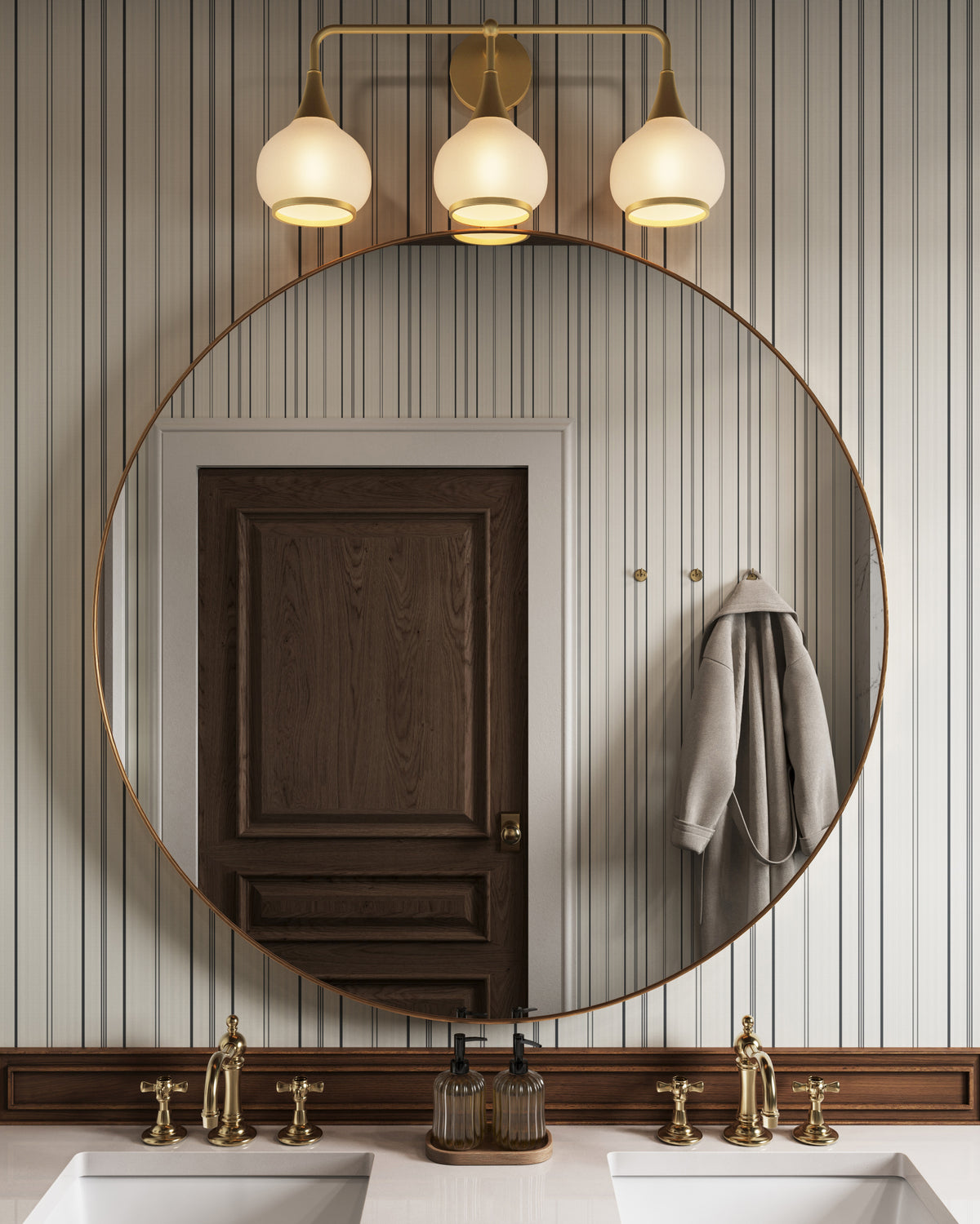Bathroom vanity with large round mirror, aged gold three-light fixture with opal glass shades, and double sinks with brass faucets.